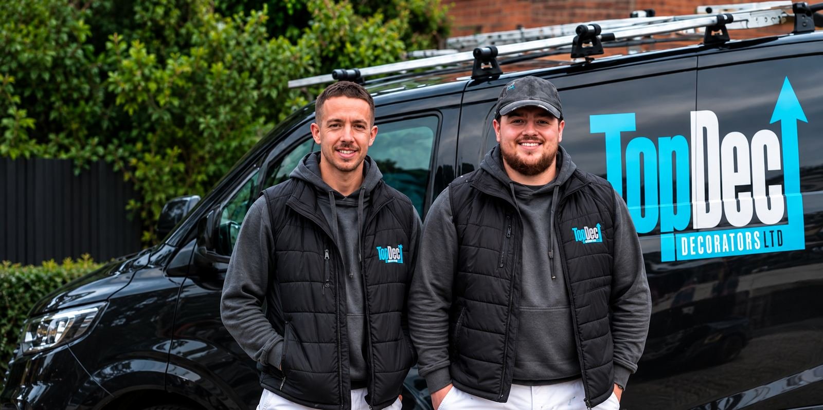 Declan and Callum from TopDec Decorators standing in front of their branded van